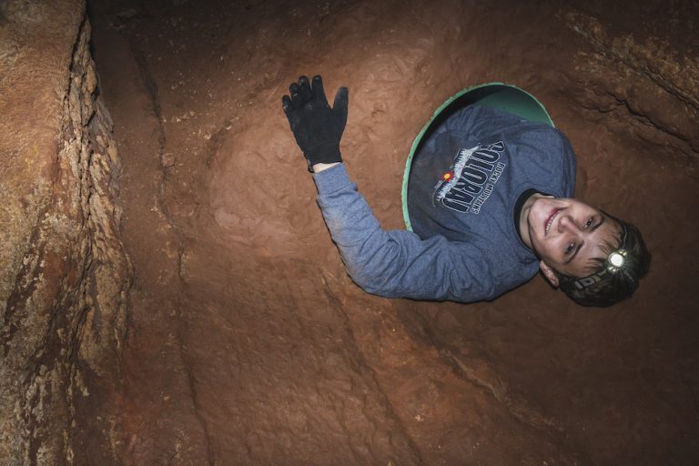 Teenager spelunking in cave of the winds cave